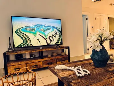 a living room with a flat screen tv and a table at Luxurious 1BR Aprt Burj Khalifa Area in Dubai