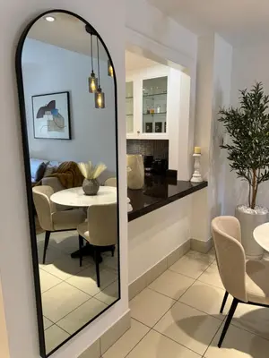 a mirror in a living room with a dining room at Luxurious 1BR Aprt Burj Khalifa Area in Dubai