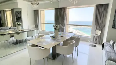 a dining room with a table and chairs and the ocean at JBR Beachfront Luxe apartment all Rooms Sea Facing in Dubai