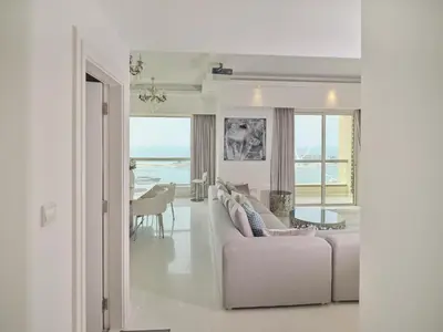 a living room with a couch and a dining room at JBR Beachfront Luxe apartment all Rooms Sea Facing in Dubai