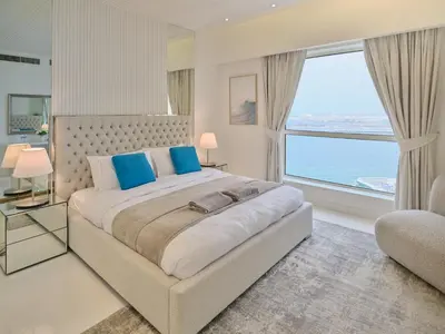 a bedroom with a large bed and a large window at JBR Beachfront Luxe apartment all Rooms Sea Facing in Dubai