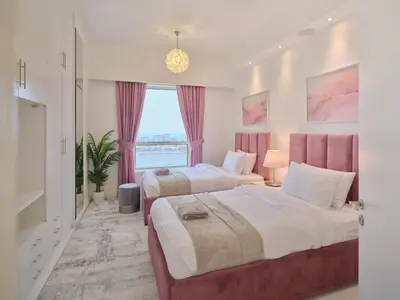 a bedroom with two beds and a window at JBR Beachfront Luxe apartment all Rooms Sea Facing in Dubai