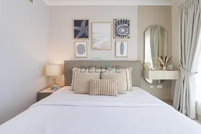 a bedroom with a large white bed with pillows at Chic Studio in Burj Views Podium, Downtown Dubai by Deluxe Holiday Homes in Dubai