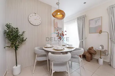 a dining room with a table and chairs and a clock at Chic Studio in Burj Views Podium, Downtown Dubai by Deluxe Holiday Homes in Dubai
