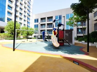 a playground in front of a building with a slide at Chic Studio in Burj Views Podium, Downtown Dubai by Deluxe Holiday Homes in Dubai