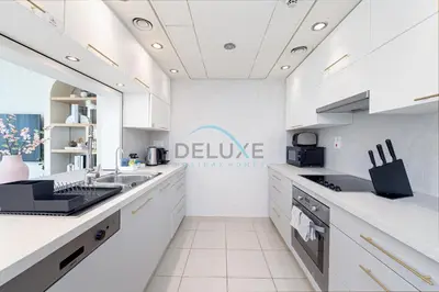 a white kitchen with a sink and a counter at Chic Studio in Burj Views Podium, Downtown Dubai by Deluxe Holiday Homes in Dubai