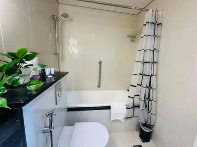 a bathroom with a toilet and a bath tub at Lovely Studio in Damac Maison Cour Jardin Business Bay in Dubai
