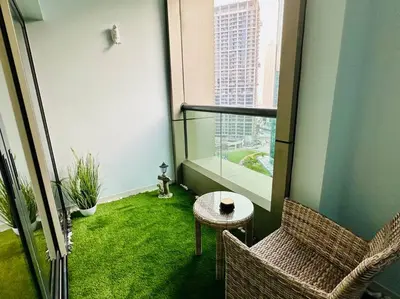 a balcony with two chairs and a table and a window at Lovely Studio in Damac Maison Cour Jardin Business Bay in Dubai