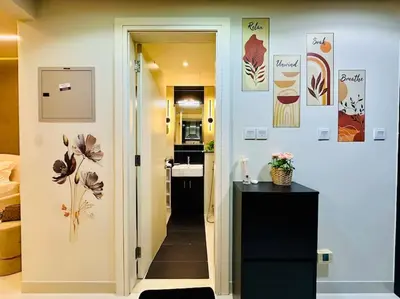 a hallway leading to a room with a kitchen and a bathroom at Lovely Studio in Damac Maison Cour Jardin Business Bay in Dubai