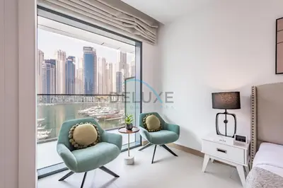 two chairs in a bedroom with a view of the city at Modern 2BR in VIDA Residences Dubai Marina by Deluxe Holiday Homes in Dubai