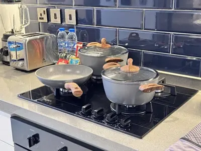 three pots and pans on a stove in a kitchen at kinda Holiday Homes- Mag 318 Downtown in Dubai