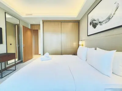 a bedroom with a large white bed and a television at Skyline Retreat 3 Bedroom at Address Opera I Burj Khalifa & Fountain Views in Dubai