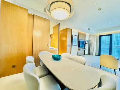 a dining room with a white table and chairs at Skyline Retreat 3 Bedroom at Address Opera I Burj Khalifa & Fountain Views in Dubai