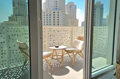 a balcony with a table and chairs and a view of a city at Private Spa 1BR Biophilic Retreat With Beach Access & Infinity Pool in Dubai
