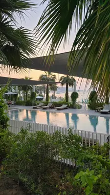 a swimming pool with a view of the ocean at Private Spa 1BR Biophilic Retreat With Beach Access & Infinity Pool in Dubai