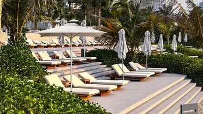 a row of lounge chairs and umbrellas at a resort at Private Spa 1BR Biophilic Retreat With Beach Access & Infinity Pool in Dubai