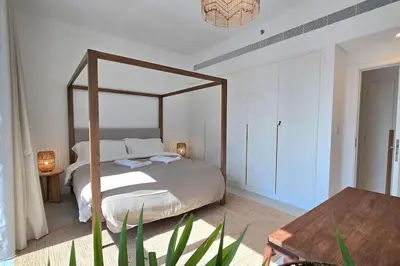 a bedroom with a canopy bed and a table at Private Spa 1BR Biophilic Retreat With Beach Access & Infinity Pool in Dubai