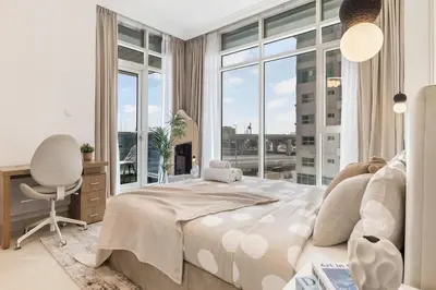 a bedroom with a bed and a desk and a window at Elegant 3BR Lux Stay in the Heart of Dubai Marina in Dubai