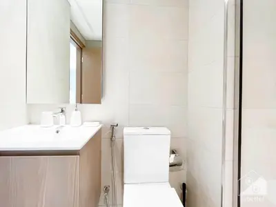 a bathroom with a toilet and a sink and a mirror at Breath taking Studio with Balcony & Stunning Views in Dubai
