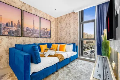 a blue couch in a living room with a window at Beachfront 1 Bedroom Apartment on Palm Jumeirah with Stunning Sea Views and Rooftop Infinity Pool in Dubai