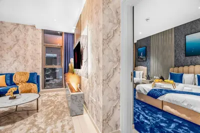 a bedroom with a king sized bed and a living room at Beachfront 1 Bedroom Apartment on Palm Jumeirah with Stunning Sea Views and Rooftop Infinity Pool in Dubai