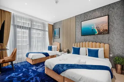 a hotel room with two beds and a tv on the wall at Beachfront 1 Bedroom Apartment on Palm Jumeirah with Stunning Sea Views and Rooftop Infinity Pool in Dubai
