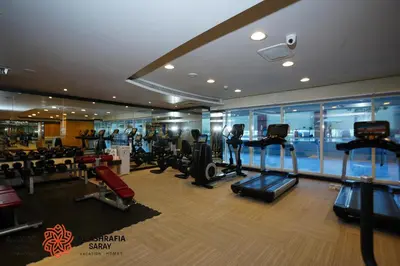 a gym on a cruise ship with treadleys and ellipticals at Alashrafia Saray- Upscale 1bdr apartment in Canal Views in Dubai