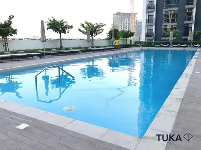 a large blue swimming pool in a city at Stunning 2-BHK Golfville at Dubai Hills Prime in Dubai