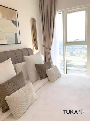 a bedroom with a large bed with pillows and a window at Stunning 2-BHK Golfville at Dubai Hills Prime in Dubai