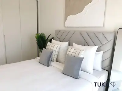 a white bed with white pillows on top of it at Stunning 2-BHK Golfville at Dubai Hills Prime in Dubai