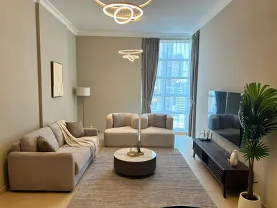 a living room with two couches and a tv at 1BR in Mayfair tower Business bay! Burj views, close to Dubai mall in Dubai