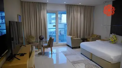 a bedroom with a bed and a living room with a tv at Alashrafia Saray- Peaceful studio in Canal Views in Dubai