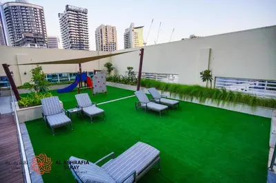 a patio with chairs and a playground on a building at Alashrafia Saray- Peaceful studio in Canal Views in Dubai