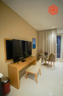 a living room with a television and a table with a chair at Alashrafia Saray- Peaceful studio in Canal Views in Dubai