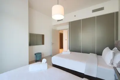 a hotel room with two beds and a television at 2BR Beachfront Living, Stunning Marina Views in Dubai