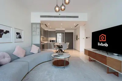 a living room with a couch and a tv at 2BR Beachfront Living, Stunning Marina Views in Dubai