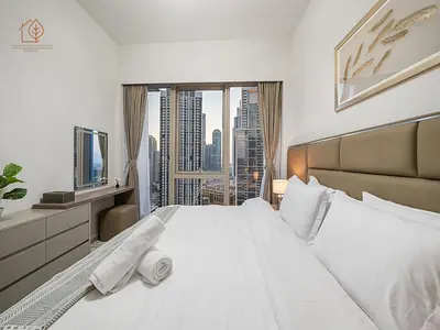 a bedroom with a large white bed with a large window at Luxury Home with City Views Near Dubai Mall 196GR-1 in Dubai