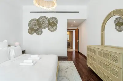 a bedroom with a white bed and a mirror at DAYF-ALI City's Heart Chic 1 BR Huge Terrace and Great Access in Dubai