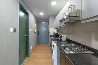 a large kitchen with a stove and a hallway at Studio Apartment featuring Alexa in Elite Residence - Allsopp & Allsopp in Dubai