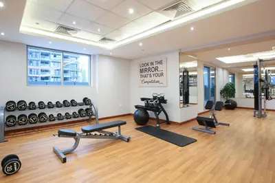 a gym with several exercise equipment in a room at Studio Apartment featuring Alexa in Elite Residence - Allsopp & Allsopp in Dubai