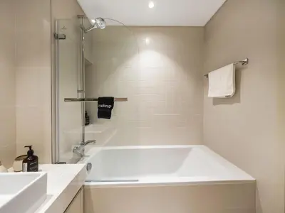 a white bath tub in a bathroom with a shower at Cozy One Bedroom on the Beach in Dubai Harbour - Prestige Retreats in Dubai