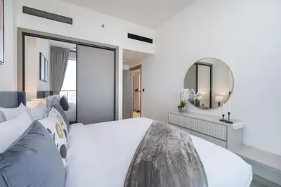 a bedroom with a large bed and a mirror at Vogue JVC Binghatti Corner near Circle Mall, One Bedroom Apartment with Balcony and City View, Access to all Amenities in Dubai