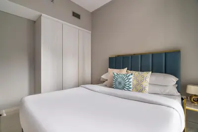 a bedroom with a white bed and a blue headboard at GuestReady - Business Bay delight in Dubai