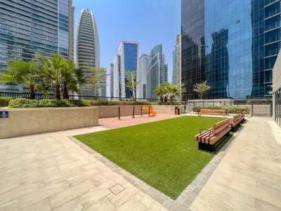 a park with benches and grass in a city at GuestReady - Business Bay delight in Dubai
