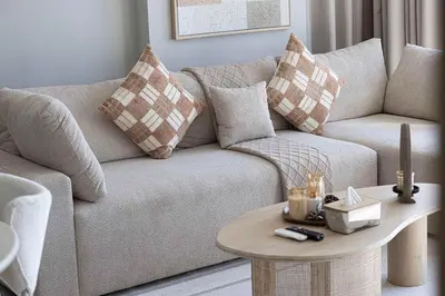 a living room with a couch and a table at Cozy Boho Retreat One Bedroom Sanctuary in Dubai