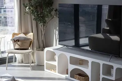 a living room with a table and a chair at Cozy Boho Retreat One Bedroom Sanctuary in Dubai