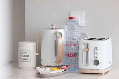 a counter with a coffee maker and a bottle of water at Cozy Boho Retreat One Bedroom Sanctuary in Dubai