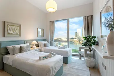 a hotel room with two beds and a large window at Elegant Retreat with Stunning Burj Khalifa Views in Dubai
