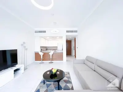 a living room with a couch and a table at Modern 1B with Balcony, Gym & Pool Access in Dubai