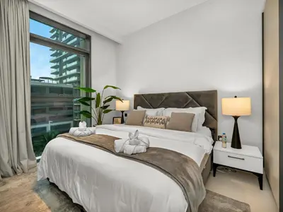 a bedroom with a large bed with two towels on it at Designer Large 1 BR with Private Beach Infinity pool in Dubai Harbour in Dubai